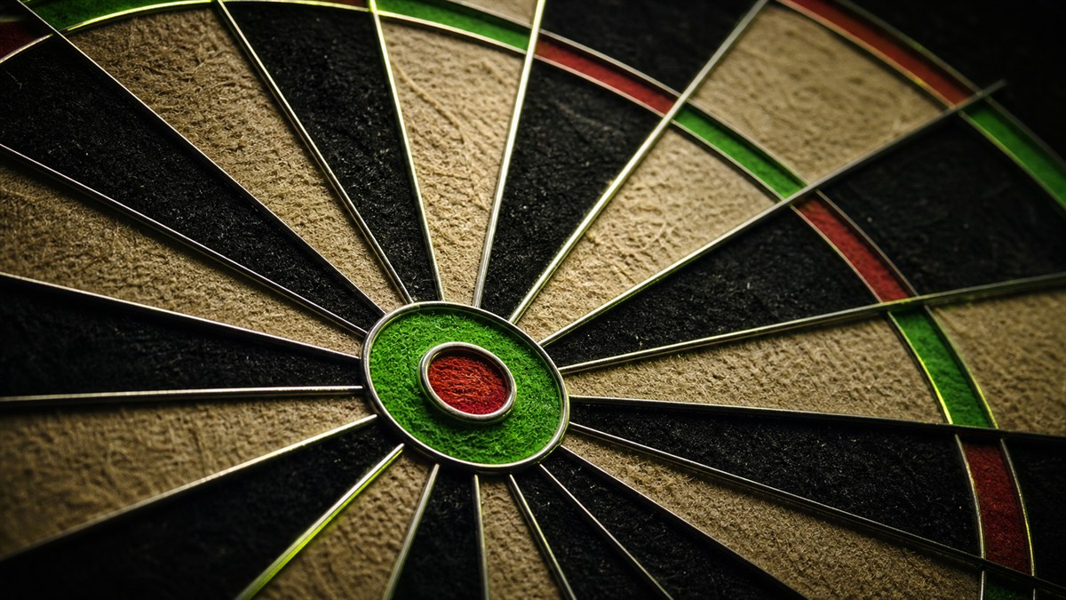 Tournament-style bristle dartboard in a dark venue